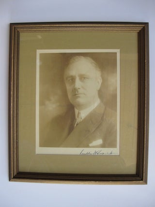 Portrait photograph of Franklin Delano Roosevelt, 32nd President of the United States (1933-1945), as Governor of New York (1929-1932), showing him looking straight ahead, slightly over his left shoulder, in suit jacket and silk tie, pocket handkerchief showing, his bold signature in the lower margin.
