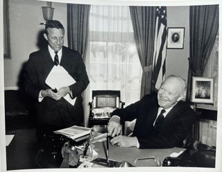 Item #68008 Black & white photograph of a smiling President Dwight D. Eisenhower, sitting at his...